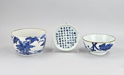 trois bols en porcelaine bleue et blanche et un bol portant une inscription