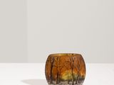 un vase en verre orange posé sur une table blanche