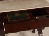 a marble top desk with a drawer underneath it