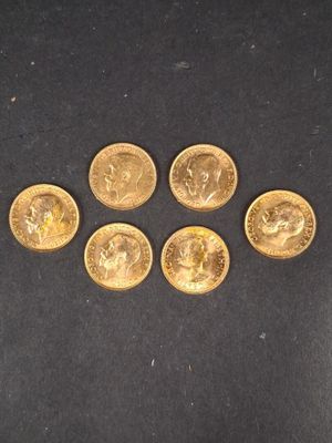 un groupe de cinq pièces d'or posées sur une surface noire