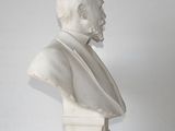 a white bust of a man on a white table