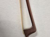 a wooden stick with a long handle on a white surface