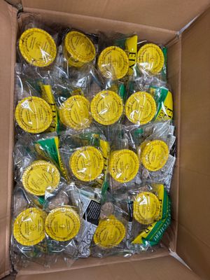une boîte en carton remplie d'une multitude de sucettes jaunes et vertes