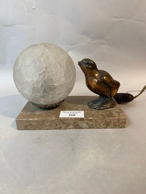 a statue of a bird and a ball on a marble base
