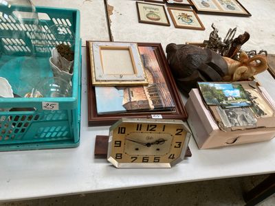 une table sur laquelle se trouvent une horloge, des cadres photo et une autre horloge
