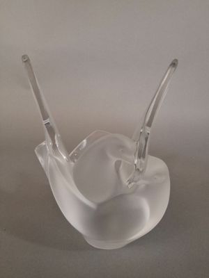 a clear glass bowl with two spoons sitting on top of it