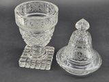 a glass candle holder and a glass candle holder on a table