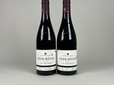 two bottles of wine sitting on top of a table