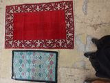 three rugs on the floor next to a pair of shoes