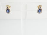 a pair of sapphire and diamond earrings on display in a glass holder