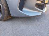a close up of a car ' s front bumper with a flat tire