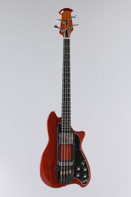 une guitare basse électrique posée sur un support, devant un fond blanc