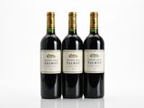 trois bouteilles de vin rouge posées sur une table blanche