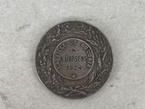 a close up of a coin on a white surface with snow