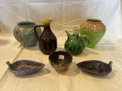 five different vases sitting on a table with a white background