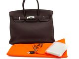 un sac à main orange et noir, avec un tissu orange et un porte-monnaie noir