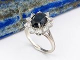 un gros plan d'une bague ornée d'un diamant noir entouré de diamants blancs