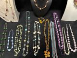 several necklaces and bracelets are displayed on a black table