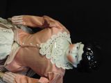 a doll that is laying down on a black surface