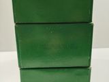 three green boxes stacked on top of each other on a table