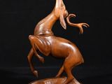 une sculpture en bois représentant un cheval sur fond noir