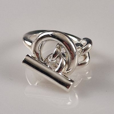 silver ring with a buckle and a chain on a white surface