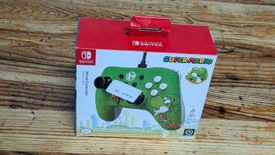 a nintendo wii controller in a box on a wooden table