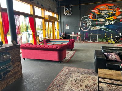 brightly colored couches and tables in a room with a large painting on the wall