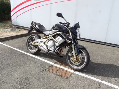a black motorcycle parked in a parking lot next to a trailer