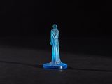 a blue glass statue of a woman standing on a black surface