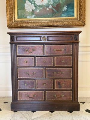 un tableau accroché au mur au-dessus d'une commode dans une pièce