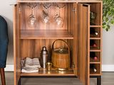 a wooden cabinet with wine glasses on top of it