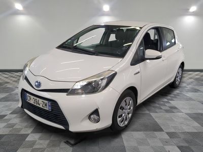 the white toyota yaris is parked on a checkered floor