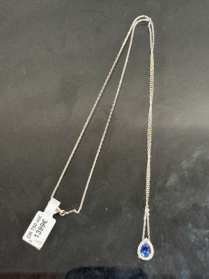 un collier en argent orné d'une pierre bleue et d'une plaque portant un nom