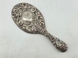 a silver spoon with a clock on it sitting on top of a table