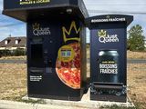 a black box with a pizza on it sitting on the side of the road