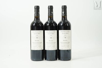 trois bouteilles de vin posées sur une table blanche