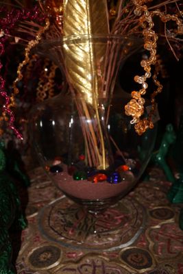 un vase en verre contenant une feuille d'or, posé sur une table