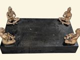 a statue of a group of people sitting on a black base