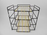 a black and yellow wire rack with four shelves
