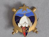 un insigne surmonté d'une étoile et un écusson orné d'une étoile