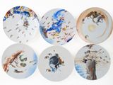 four plates with different designs on them on a white surface