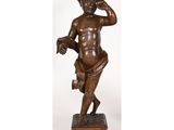 une statue en bronze représentant un garçon tenant un téléphone à la main