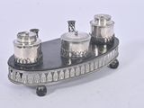 a silver plate with three silver containers on it