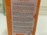 an orange bottle of hand sanitizer sitting on a counter