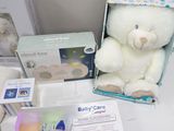 a white teddy bear sitting next to a box of baby care items