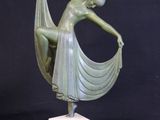 statue of a woman in a green dress holding a white cloth