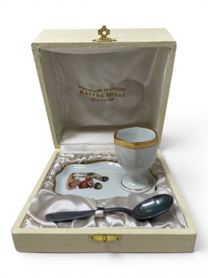 a small cup and spoon in a box on a table