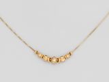 un collier plaqué or composé de cinq perles montées sur une chaîne
