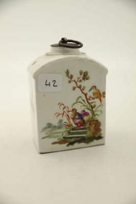 une petite boîte blanche sur laquelle est représentée une image d'oiseaux et de fleurs